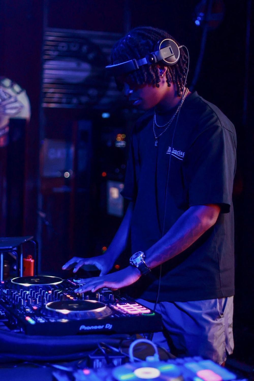 DJ Reese blending tracks under blue stage lights